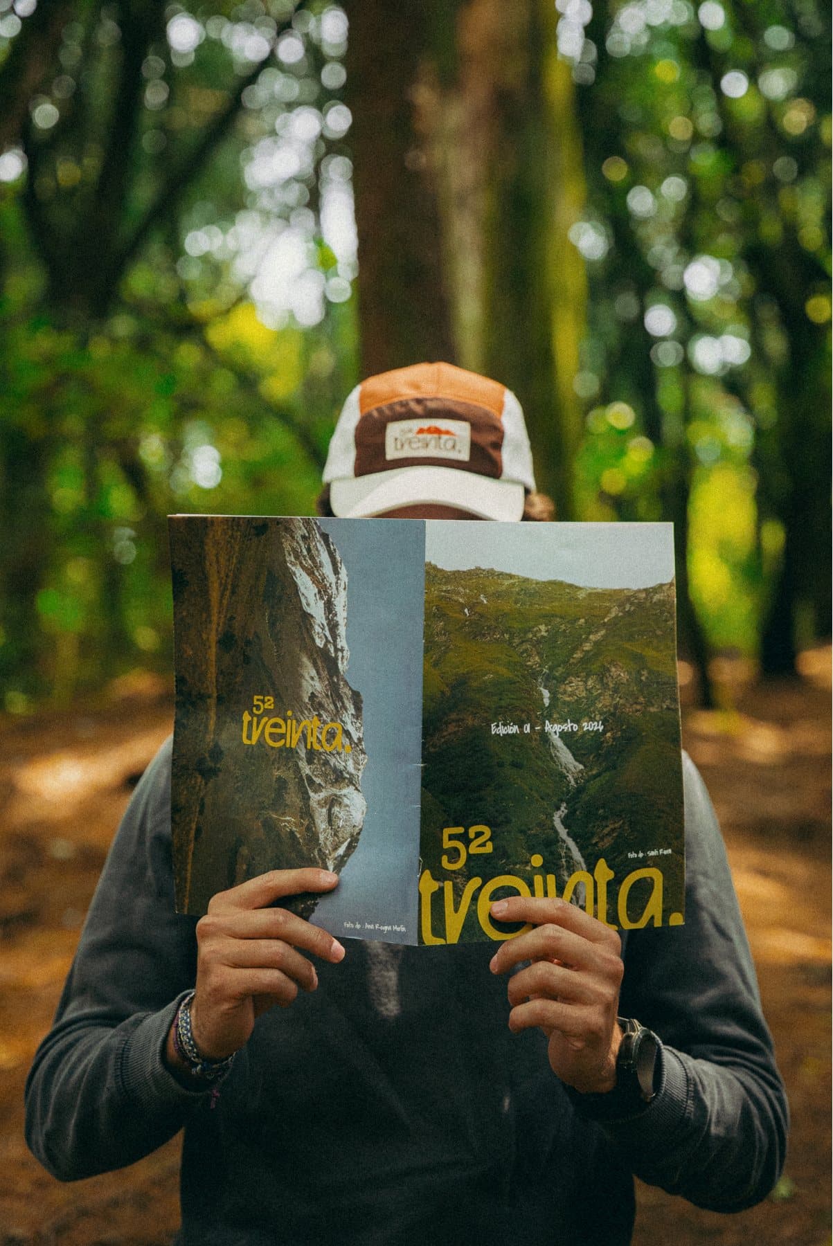 Alguien con la gorra de 52 treinta lee la revista en el bosque