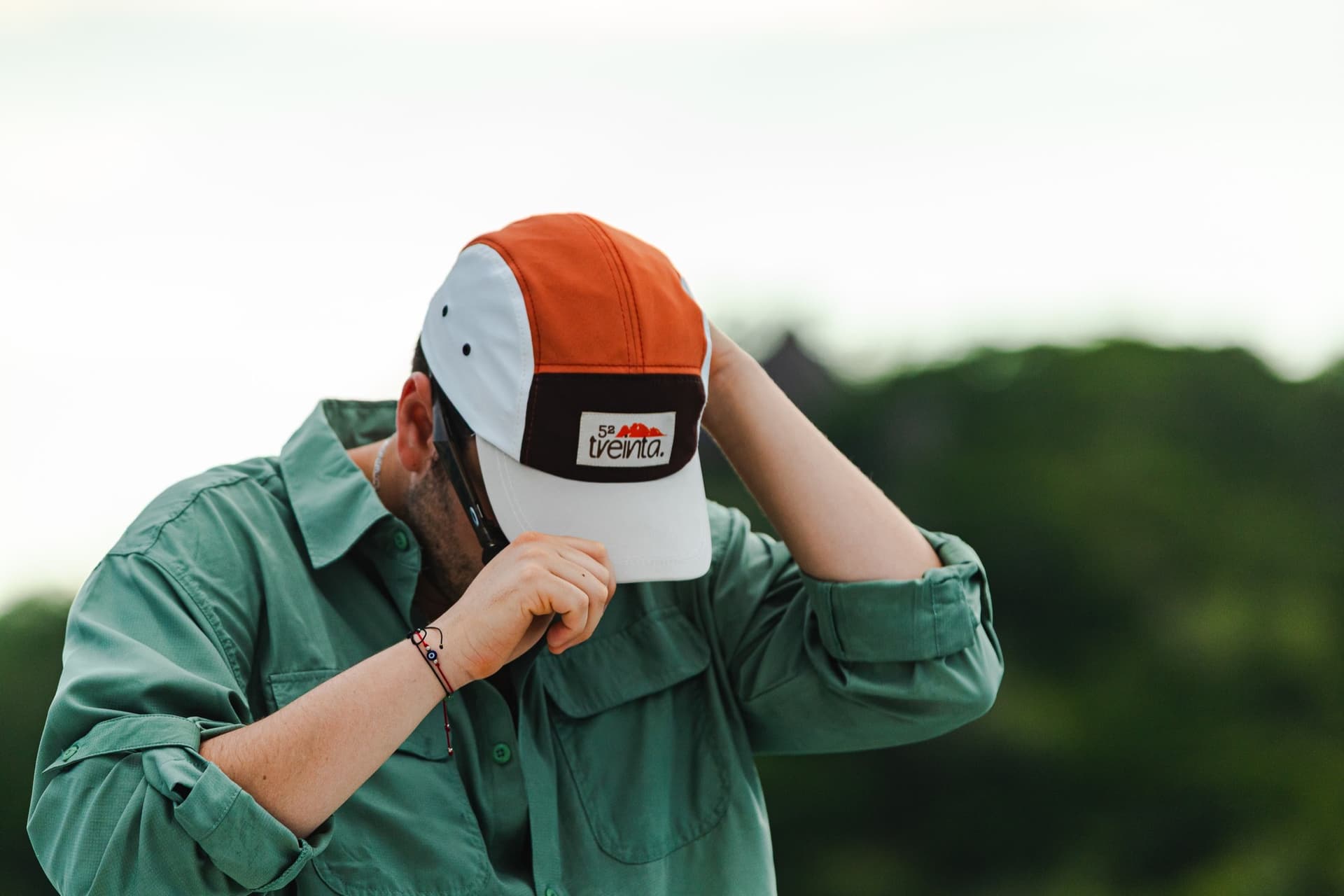 Pablo adjusts the orange and cream cap with both hands