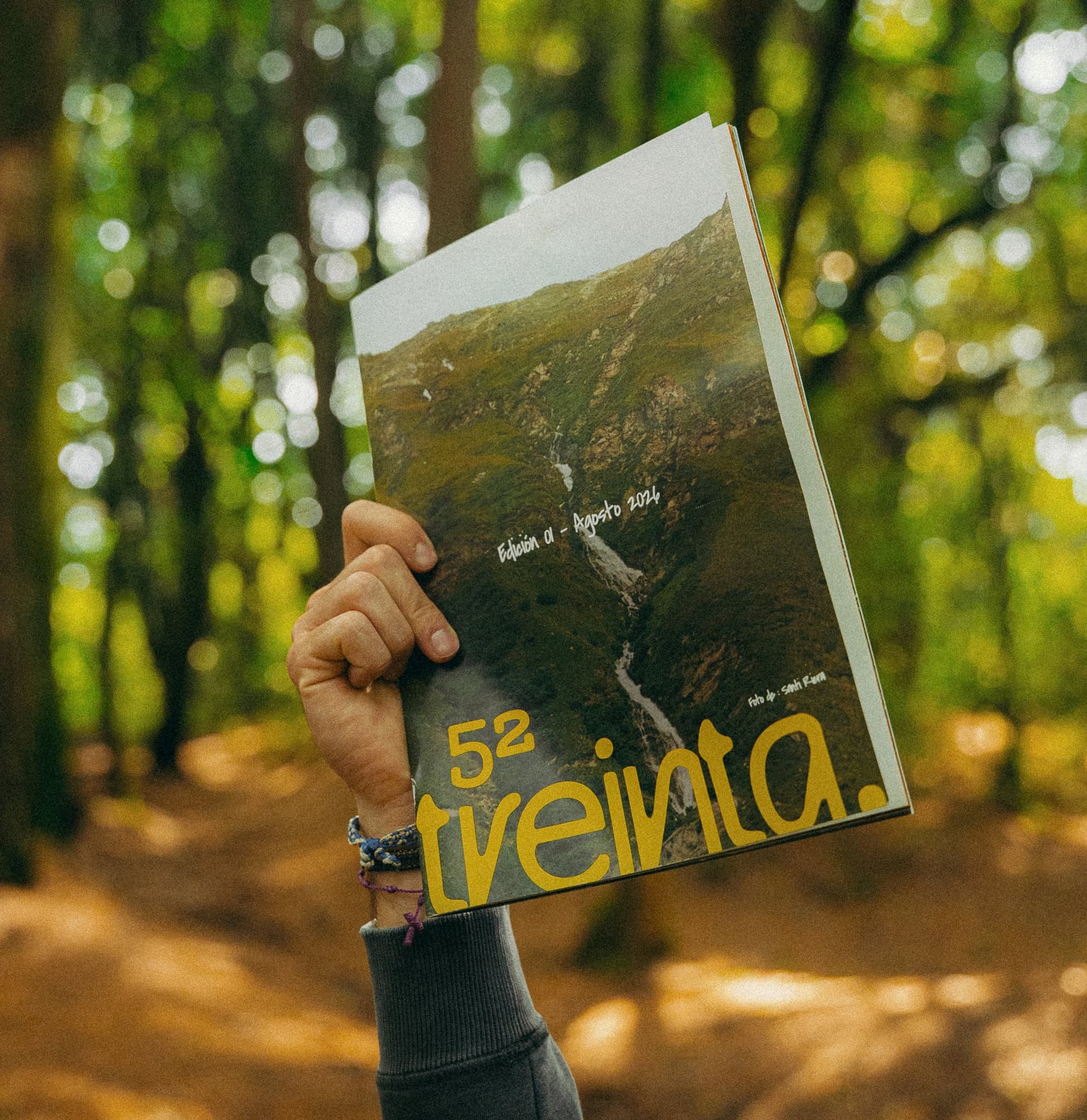 Una mano levanta la revista de 52 treinta en el bosque