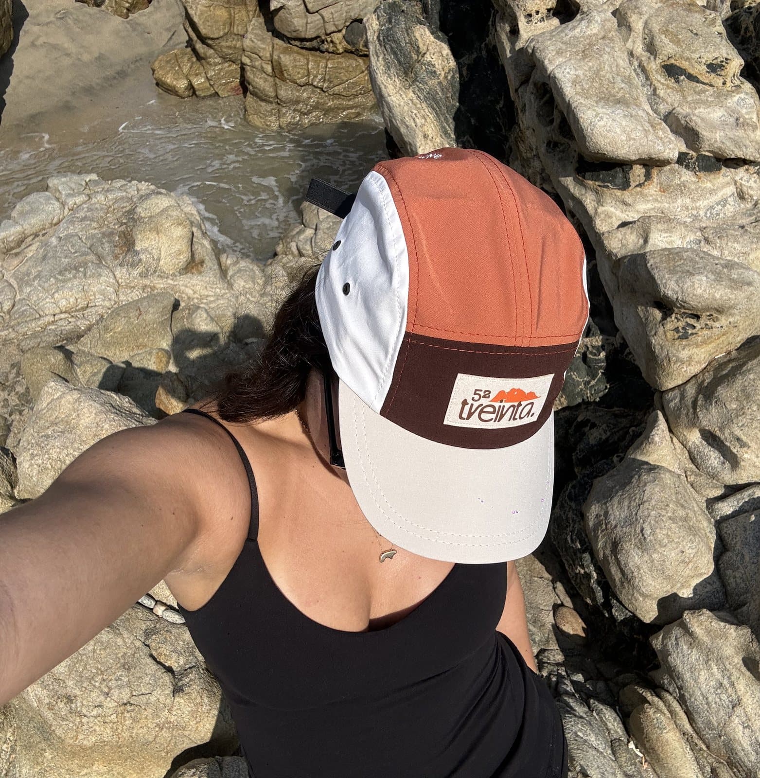 Una selfie desde arriba con la gorra, entre rocas junto al agua