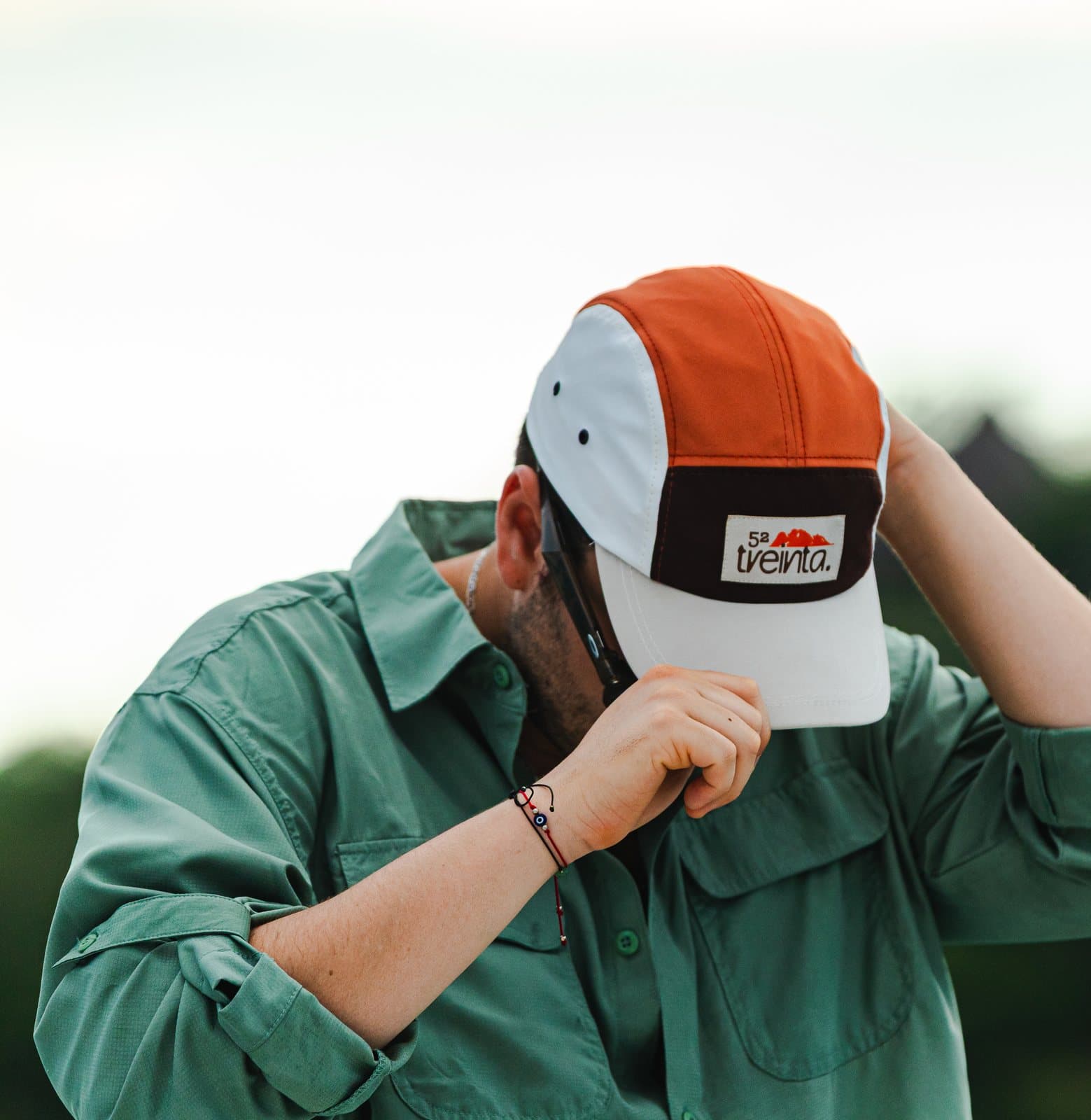 Someone adjusts the cap with both hands